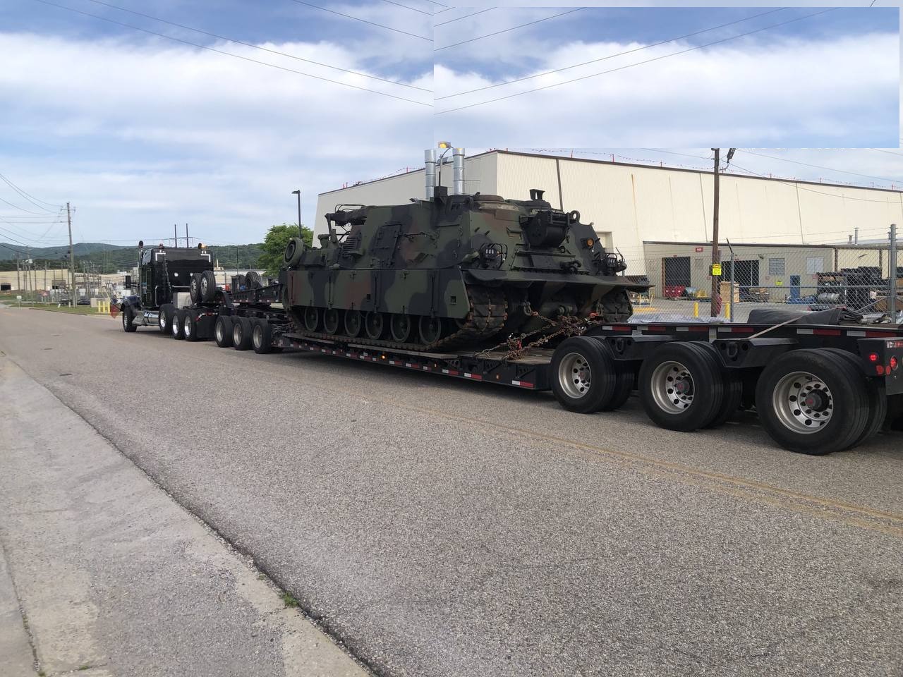 Military tracked vehicle secured on an RGN lowboy trailer